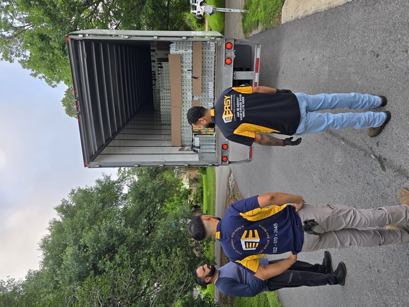 Two Easy techs unloading garage door panels from the truck